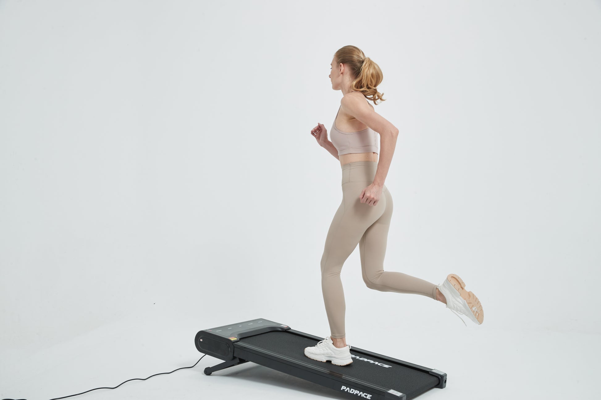 Woman running on a walking pad with auto incline