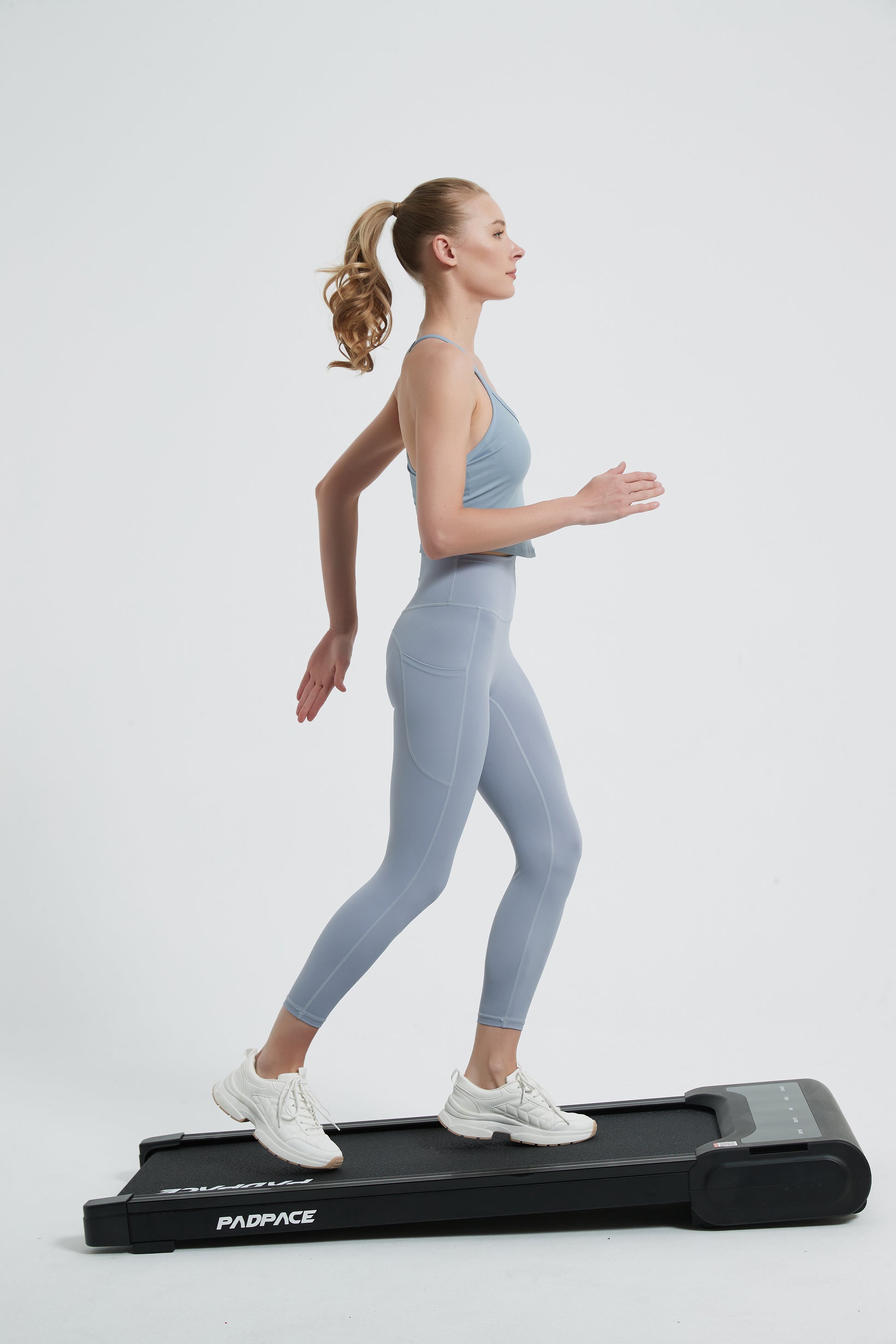 Woman walking on the PadPace walking pad with auto incline